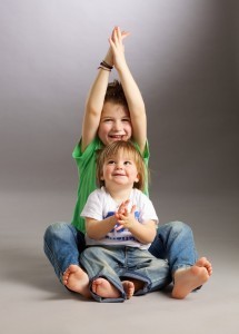 A candid studio portrait of two young kids wearing jeans and "save the future" T-shirts